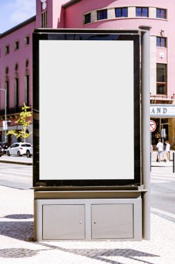 Şehrin arka planında tarihi pembe bir bina bulunan boş bir şehir reklam panosu. Model ya da reklam tasarımı sunumları için ideal.