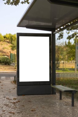 Şehirdeki bir otobüs durağındaki boş reklam panosu, modelleme veya pazarlama tasarımı için boş reklam alanı.