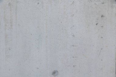 Ham beton duvarın yakın çekim dokusu. Yüzey doğal kusurları, küçük delikleri ve renk çeşitliliğini gösterir. Bitmemiş ya da endüstriyel tarzda tipik beton..