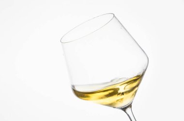 Beyaz arka plana yaslanmış bir bardak beyaz şarap. Minimum ve zarif kompozisyon..