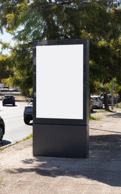 Blank urban billboard mockup on a city sidewalk in Lisbon, Portugal. Outdoor advertising display with empty white space for design or promotional content, surrounded by trees, cars, and urban street environment.