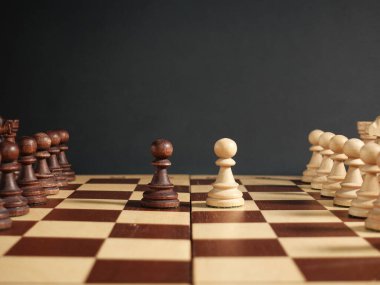 Satranç, satranç tahtasında diğer parçalarla yüz yüze siyah bir arkaplanda satranç masası. Siyah bir arkaplanda satranç. Yüksek kalite fotoğraf
