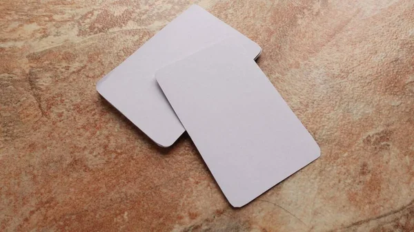 Playing cards modern mock up. Deck of playing card on a brown and beige marble surface.Blank white cards or business cards. Branding and holidays. 