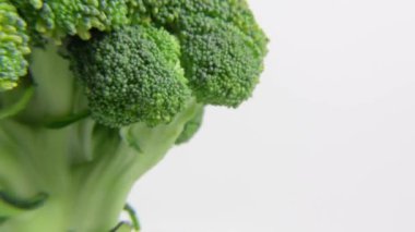 Brokoli bütün lahana yatay olarak döner, taze yeşil sebze beyazda izole edilir. Yüksek kalite 4k görüntü
