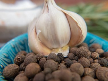 Close up garlic with pepper . Extra close up still life with depth of field. Spices. Blue cup. High quality photo