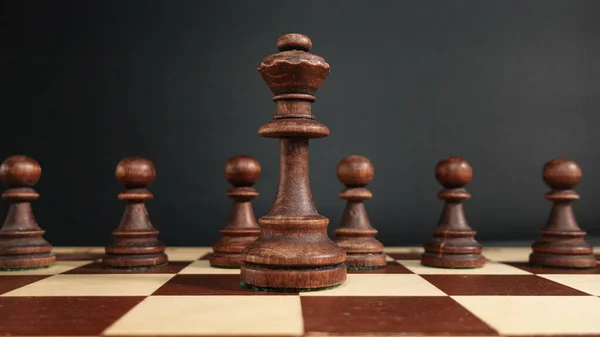 stock image A black chess queen against the background of an army of black pawns.Chess great background. Banner for advertising a chess school