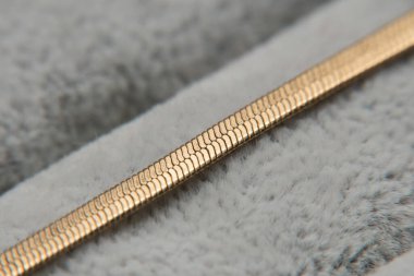 Gri üzerine altın zincirli kolye, yakın plan. Altın zincir detayları. Yüksek kalite fotoğraf