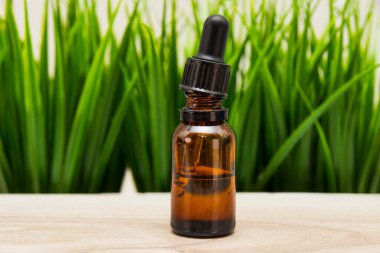 Doğal organik kozmetik konsepti. Yeşil çimen arka planına karşı cam şişe kozmetik ürünü. Üretimin taklidi. Yaklaş. Yüksek kalite fotoğraf. Yüksek kalite fotoğraf