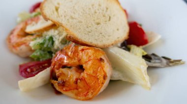 Salata sezarını beyaz tabakta karideslerle kapatın. Yüksek kalite fotoğraf