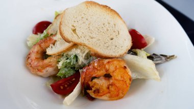 Salata sezarını beyaz tabakta karideslerle kapatın. Yüksek kalite fotoğraf