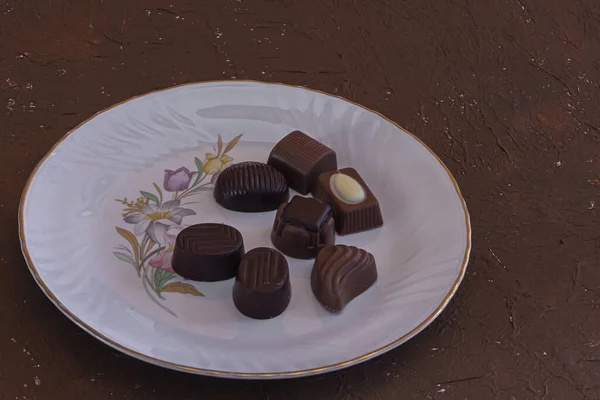 ホワイトプレートにチョコレートキャンディーの種類 — ストック写真