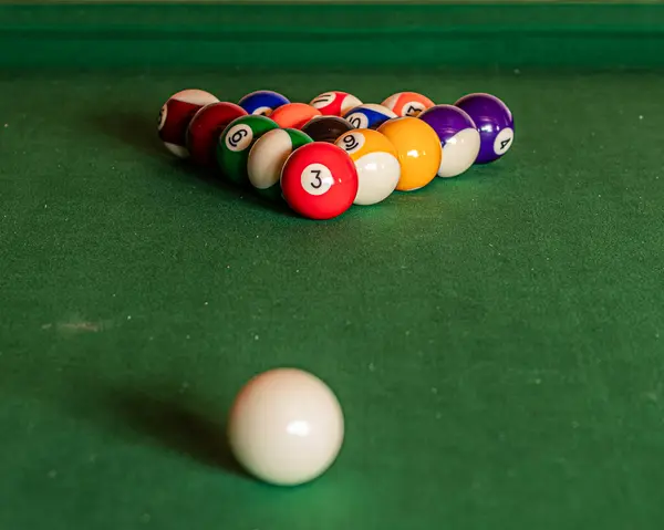 Close-up of a pool table with vibrant billiard balls, inviting a game of precision and skill