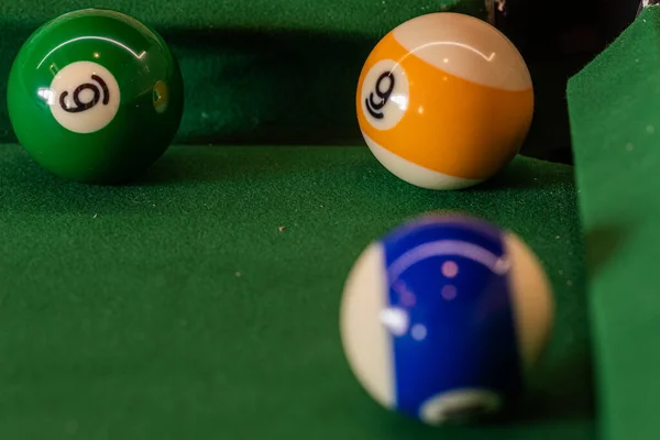 Colorful pool balls arranged on a billiard table, promising entertainment and friendly competition