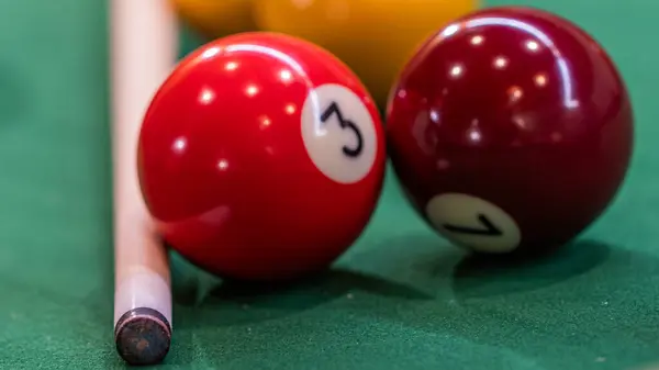 Close-up of a pool table with vibrant billiard balls, inviting a game of precision and skill