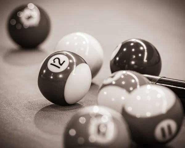Close-up of a pool table with vibrant billiard balls, inviting a game of precision and skill. Black and white picture