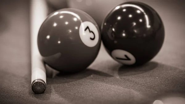 Close-up of a pool table with vibrant billiard balls, inviting a game of precision and skill. Black and white picture