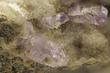 Parlak berraklığa sahip bir kaya yatağından çıkan ham ametist kristallerinin yakın çekimi