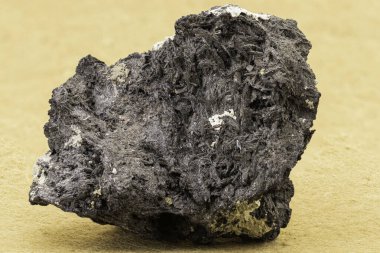 Lifli dokusu ve metalik yansımaları olan koyu mineral bir kaya. Eğitimsel, jeolojik, bilimsel veya doğal tarih temalı görsel içerik için ideal