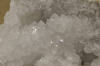 Bir kaya boşluğu içinde beyaz kristal bir oluşumun yakın plan görüntüsü, muhtemelen kuvars veya kalsit. Jeolojik, bilimsel, doğal tarih veya bilimle ilgili hisse senedi içeriği için uygundur