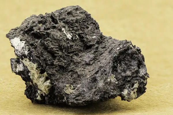 Fibröz yapısını ve metalik parıltısını gösteren koyu mineral numunesinin makro fotoğrafı. Stok fotoğrafçılığında jeoloji, toprak bilimi, mineraloji veya eğitim amaçlı kullanışlı