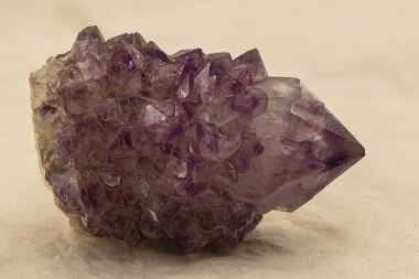 Canlı menekşe sonlandırmaları ve detaylı yüzler içeren ham ametist kristalinin makro görüntüsü. Mineral koleksiyoncuları, mücevher meraklıları ve eğitici ya da ruhani amaçlar için mükemmel bir doğal örnek.