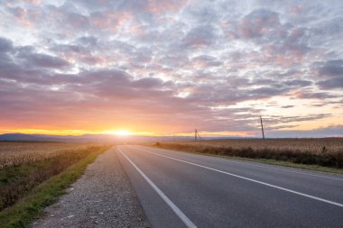 Günbatımında boş asfalt yol Sihirli gökyüzü.