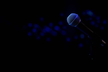 Mikrofon ve sahne ışıkları ile canlı müzik arkaplanı