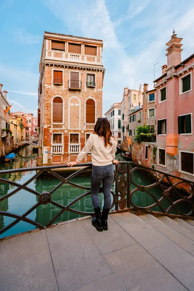 Venedik, İtalya - Ekim 2022: Venedik kanallarındaki karakteristik bir binaya arkadan bakan kadın