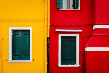 Burano, İtalya - Ekim 2022: Pencereli sarı ve kırmızı renkli evler