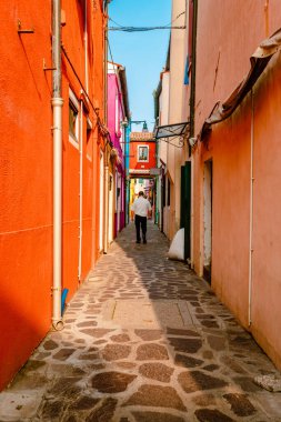 Burano, İtalya - Ekim 2022: Burano 'nun turistlerle dolu renkli geçidi