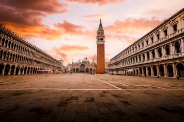 Venice, Italy - November 2022: St. Mark's Square (Piazza San Marco) in Venice with few people and birds in flight at dawn