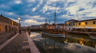 Sunrise with moving clouds over Cesenatico harbor with ancient sailboats, Timelpase 4K
