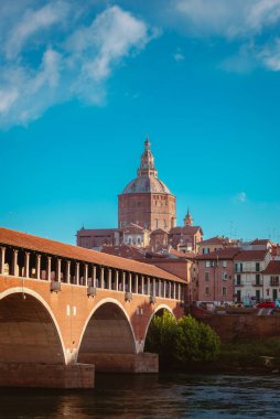 Pavia, İtalya - 20 Nisan 2024: Pavia Katedrali 'nin arkasında Ponte Vecchio, beyaz bulutlu mavi gökyüzü, dikey