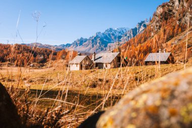 Alpe Devero, Italy - 10 November 2024: Small mountain houses nestled in mountain clearing in autumn clipart