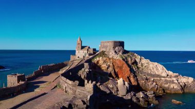 Portovenere cliffside with bright houses and open sea in the background