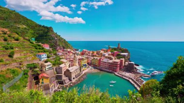 Vernazza kasabası yukarıdan görünen kıyı kayalıkları ve mavi gökyüzünün altında sakin deniz