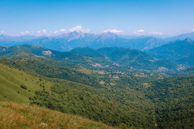 İtalya 'nın kuzeyindeki yeşil tepeler ve açık gökyüzü ile geniş bir manzara..