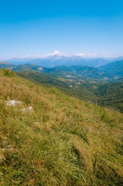 Monte Palanzone, Como - 22 Haziran 2025: Monte Palanzone 'un tepesinden yürüyüş göstergeleri görkemli bir dağ manzarasını işaret ediyor.