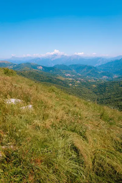 Monte Palanzone, Como - 22 Haziran 2025: Monte Palanzone 'un tepesinden yürüyüş göstergeleri görkemli bir dağ manzarasını işaret ediyor.