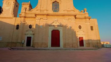 Oria, Brindisi - 7 Ağustos 2025: Oria Katedrali 'nin barok cephesinin akşam ışığı altında ihtişamını ve detaylarını vurgulayan düşük açılı bir çekimi.