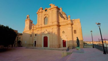 Oria, Brindisi - 7 Ağustos 2025: Oria Katedrali ve ana meydanının geniş panoramik bir çekimi, altın gün batımı ışığı ile yıkandı.