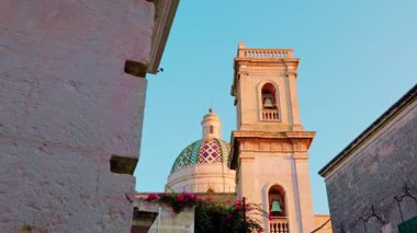 Oria, Brindisi - 7 Ağustos 2025: Oria Katedralleri kubbesi ve çan kulesinin alçak açılı panoramik çekimi, gökyüzüne karşı barok mimarisini vurguluyor.