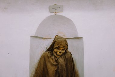 Oria, Brindisi - 7 Ağustos 2025: Oria Katedrali 'nin mahzenindeki mumyalanmış papazın yakın çekimi, tarihi dini öneme sahip cam bir kutuda korunmuş.