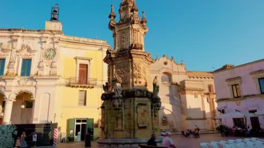 Nardo, Piazza Salandra 'daki Lekesiz Gebelik Kalesi' nin yukarı doğru görüntüsü açık bir yaz gökyüzüne karşı barok detayları vurguluyor.