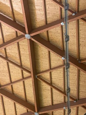 Açıkta duran kirişleri ve metal yapısı olan ahşap çatı