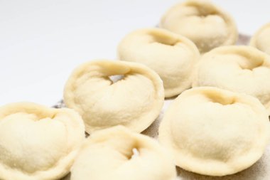 Pelmeni böreği hazırlığı. Çiğ et pelmeni, ravioli, ahşap bir tahtanın üstündeki mantı.