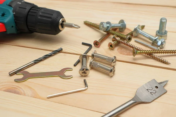 stock image set of tools on wooden table, a electric screwdriver with a set of drill bits and screws with bolts. DIY concept. Equipment, workplace. Flat lay composition.