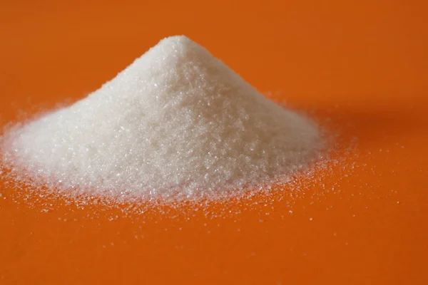 Una Colina Azúcar Granulada Sobre Fondo Naranja Montón Azúcar — Foto de Stock