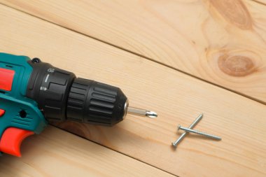 Aletli masa. Tahta bir masada elektrikli tornavida. Siyah metalik vidaların yan görünümü, Wodden tahtalarında elektrikli tornavida.