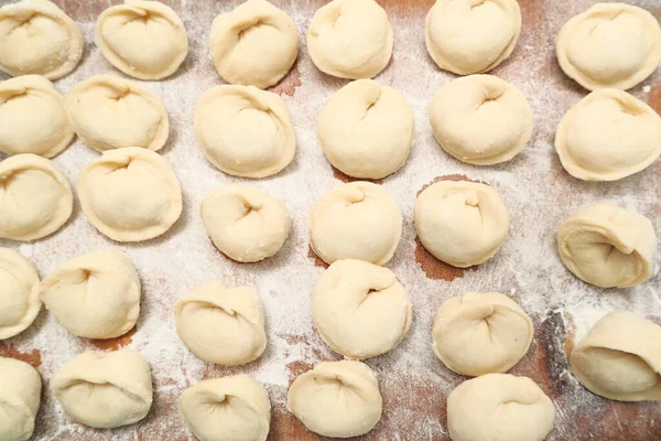 stock image Preparation of dumplings Pelmeni. Raw meat pelmeni, ravioli, dumplings top view on a wooden board